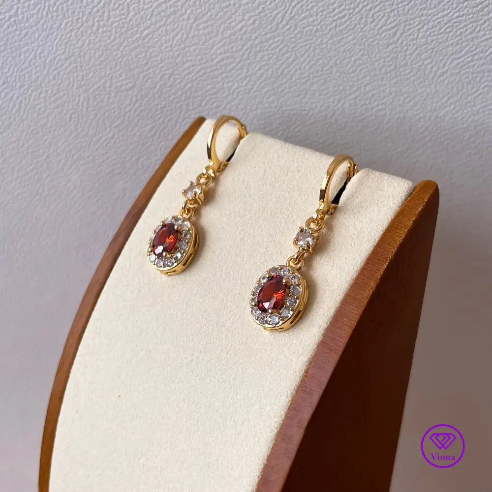 Gold plated oval earrings with main red topaz stone and small white topaz decoration