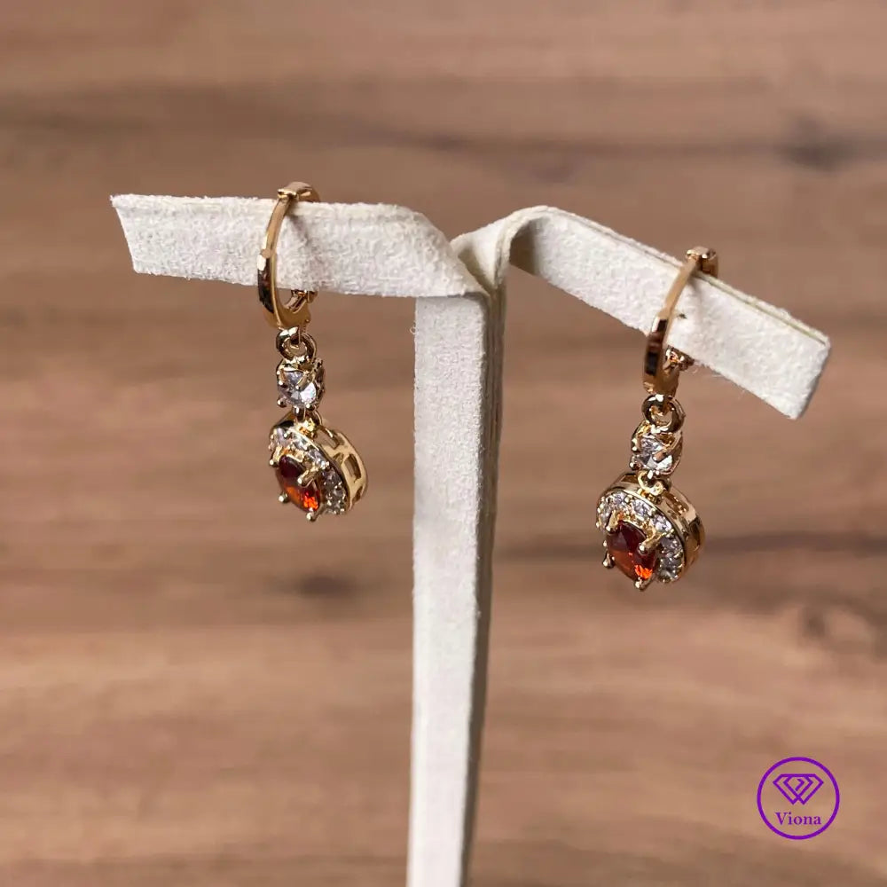 Gold plated oval earrings with main red topaz stone and small white topaz decoration