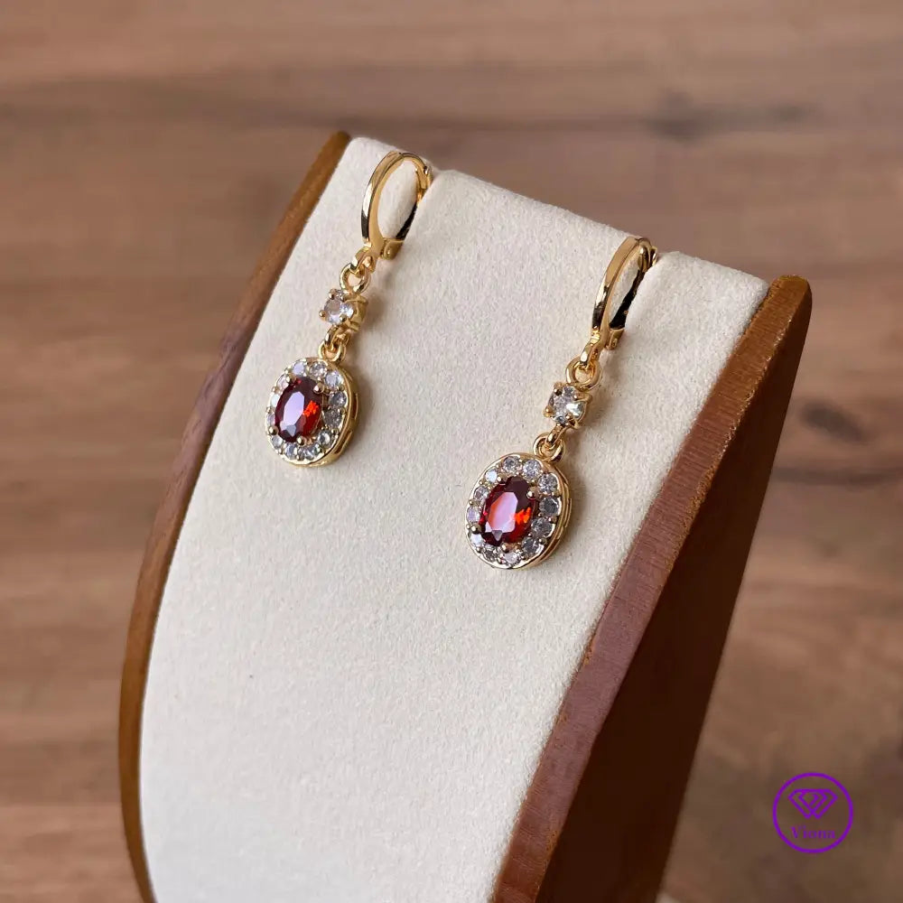 Gold plated oval earrings with main red topaz stone and small white topaz decoration