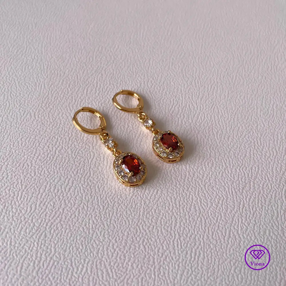 Gold plated oval earrings with main red topaz stone and small white topaz decoration