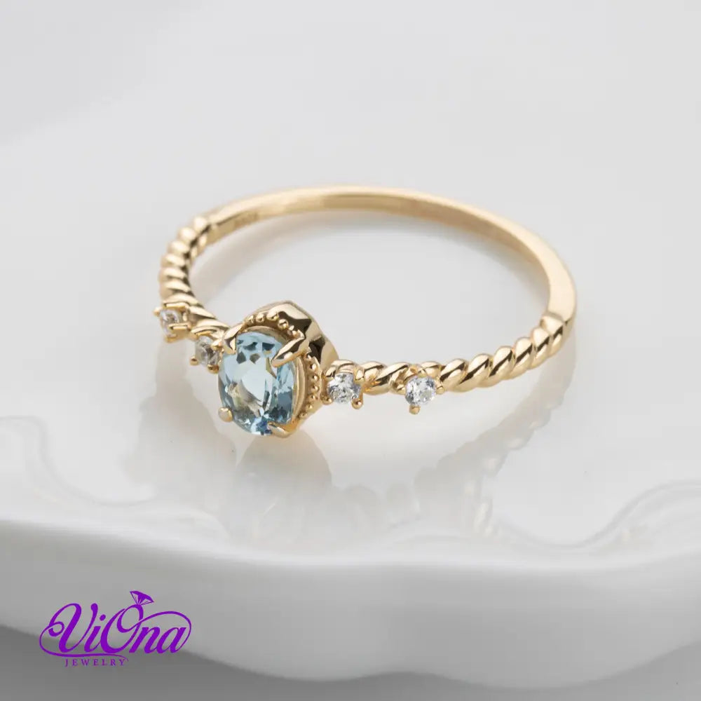 Oval Blue Topaz Gemstone Radiance: Gold-Plated 925 Sterling Silver Ring with 4 Side Stones and Intricate Rope Detailing