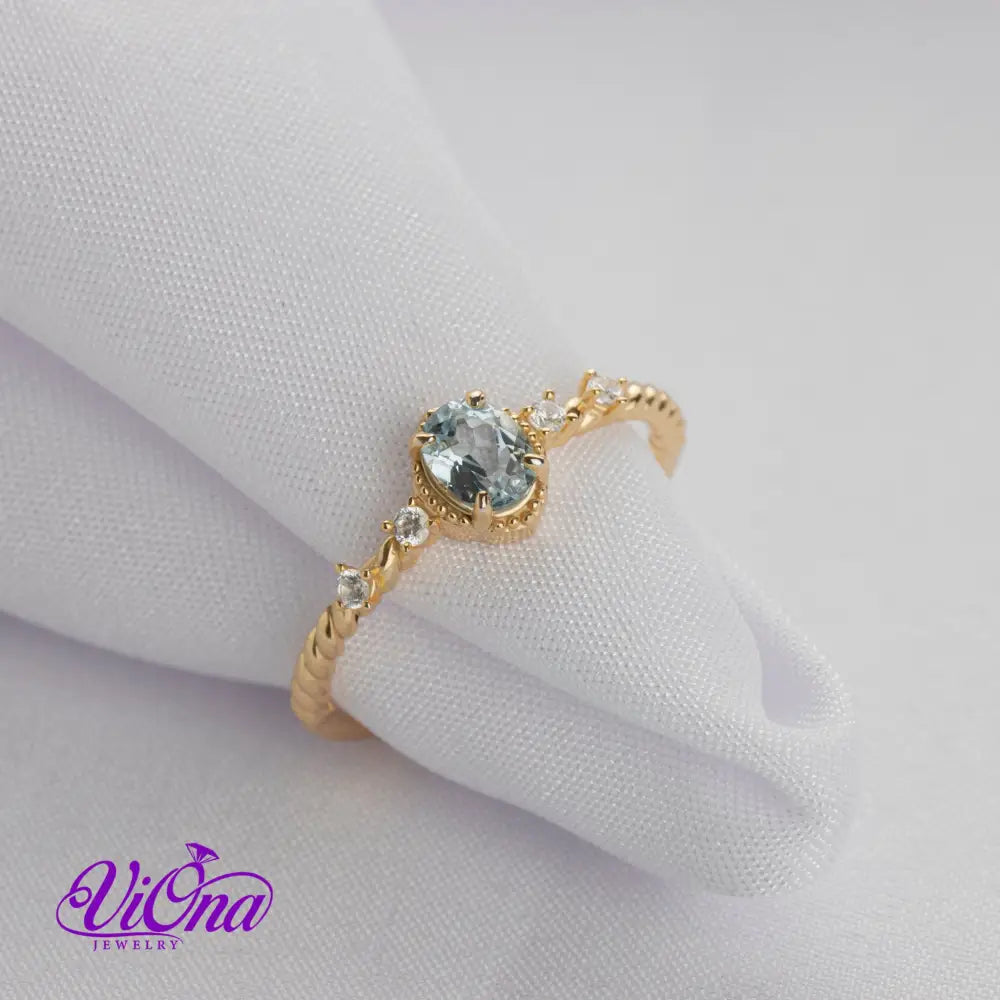 Oval Blue Topaz Gemstone Radiance: Gold-Plated 925 Sterling Silver Ring with 4 Side Stones and Intricate Rope Detailing