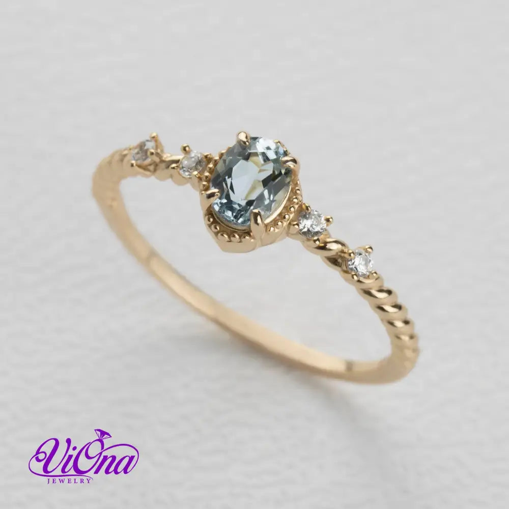 Oval Blue Topaz Gemstone Radiance: Gold-Plated 925 Sterling Silver Ring with 4 Side Stones and Intricate Rope Detailing