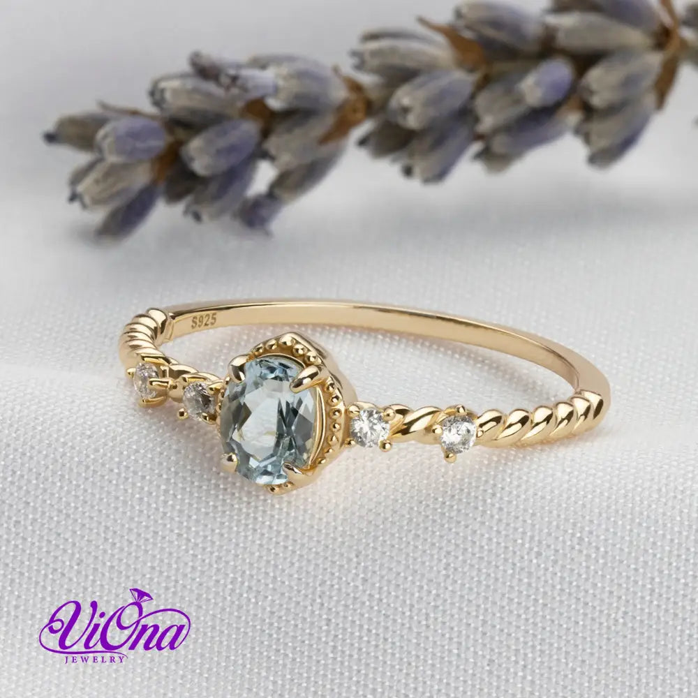 Oval Blue Topaz Gemstone Radiance: Gold-Plated 925 Sterling Silver Ring with 4 Side Stones and Intricate Rope Detailing